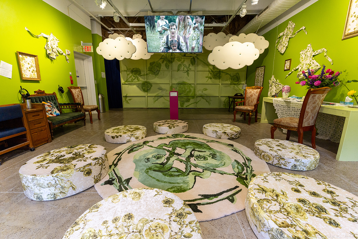 Image of a well lit room green room featuring a carpet with a green fetus design